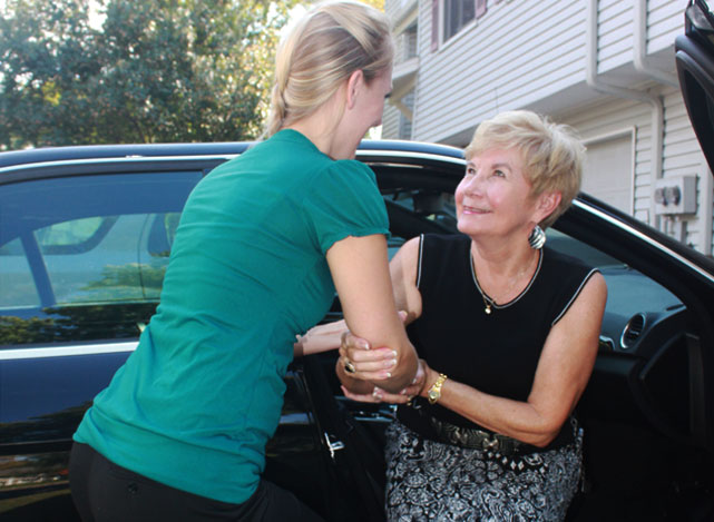 Caregiver helping client with car door