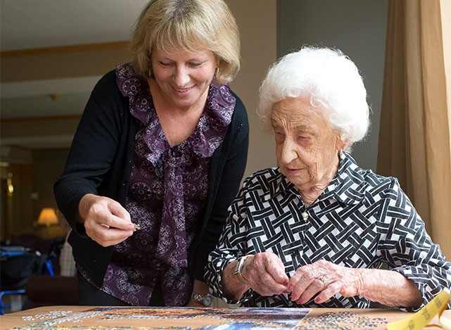 Caregiver and client putting together a puzzle