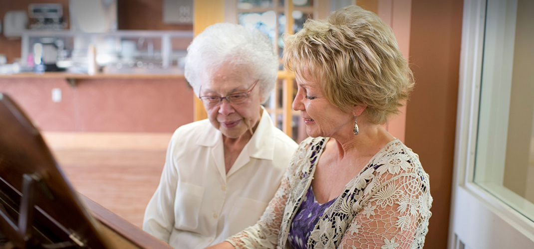 Caregiver and client sitting at a piano